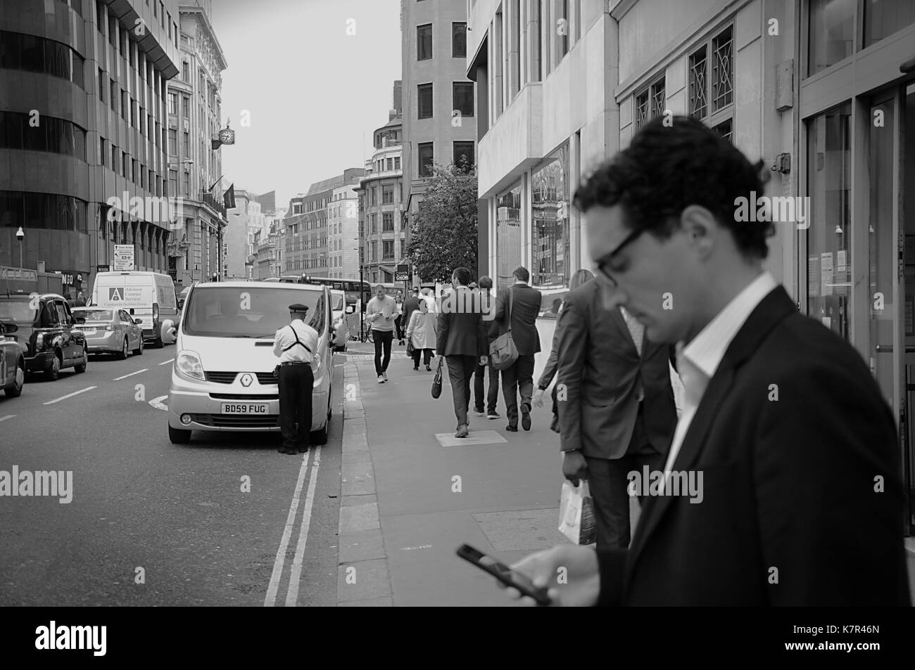 Gardien de la circulation donnant un billet pour un van dans une rue animée de Londres Banque D'Images