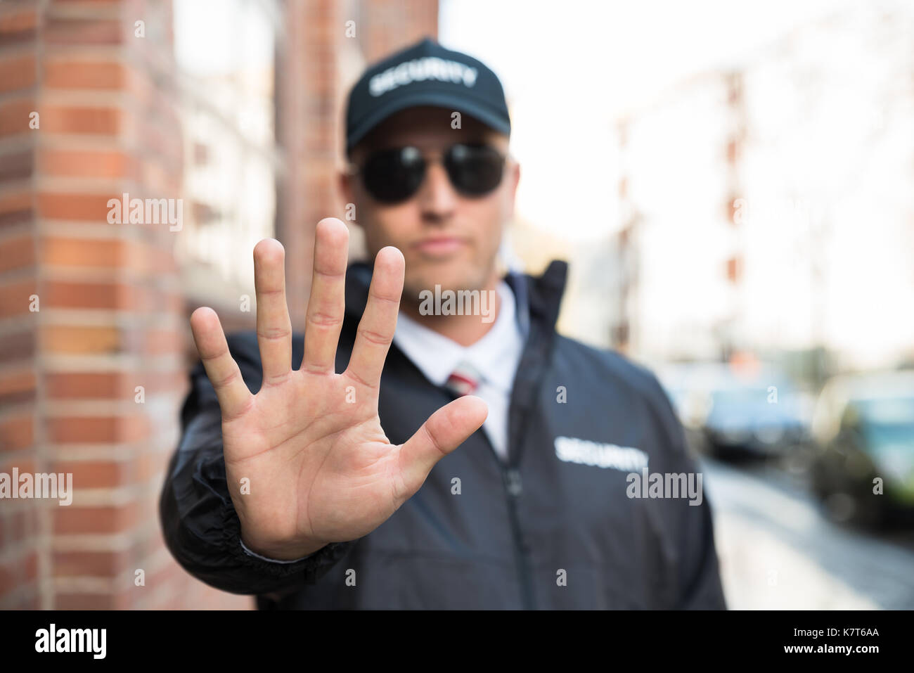 Agent de sécurité de sexe masculin faisant cesser de signer avec les mains Banque D'Images