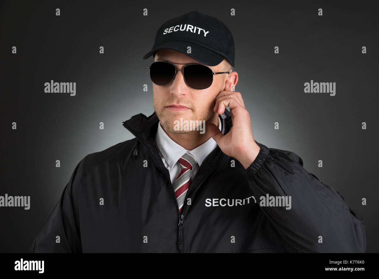 Agent des services secrets à l'écoute jusqu'à l'écouteur sur fond noir Banque D'Images