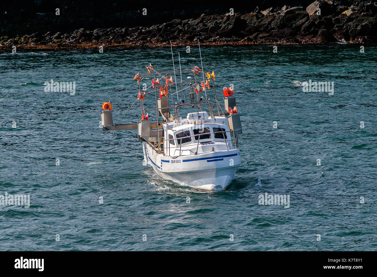 Petit bateau de pêche blanche est flottant près de la rive près de Keflavik, en Islande. Banque D'Images
