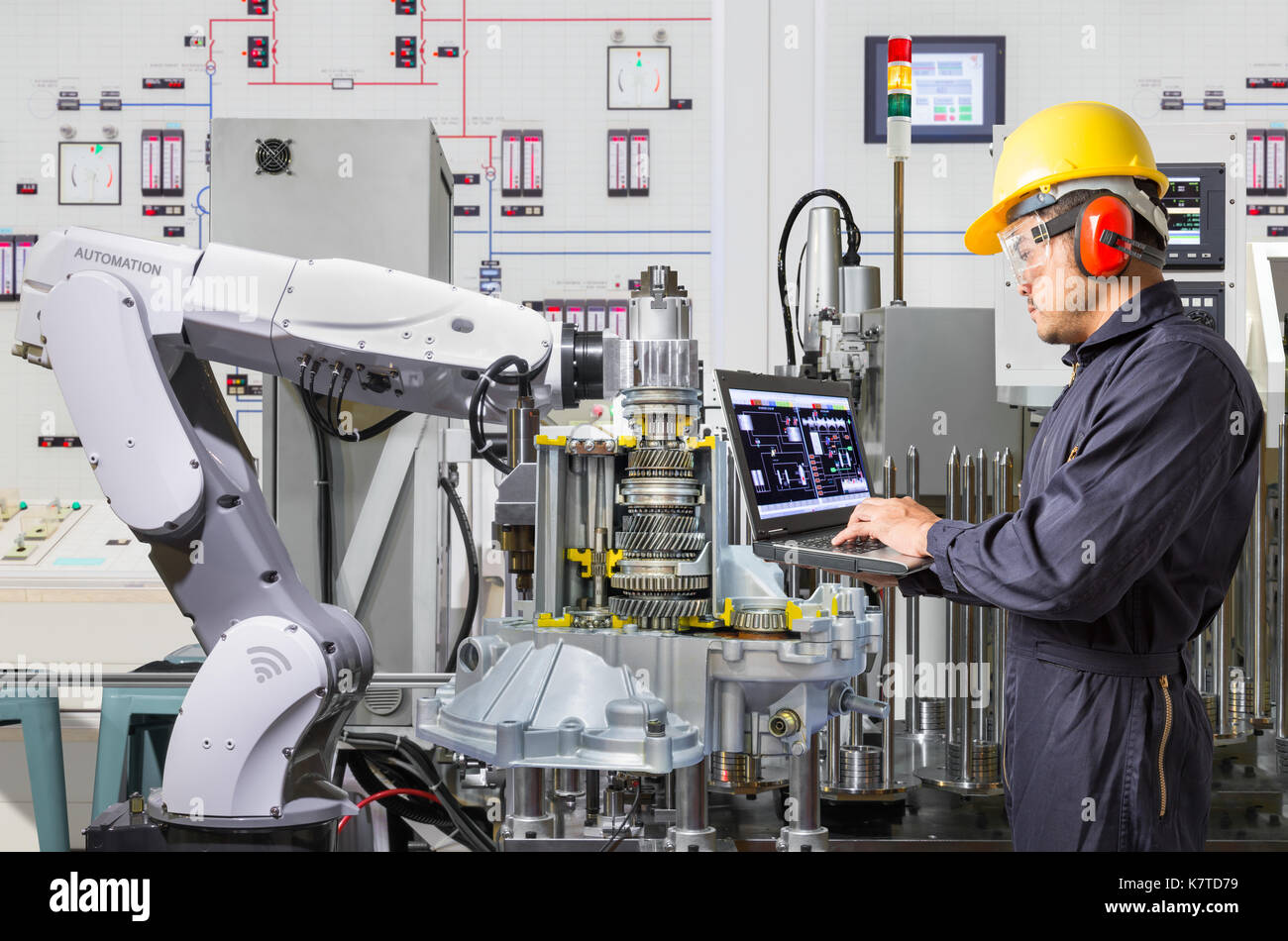 Ordinateur portable à l'aide de l'ingénieur pour l'entretien de la machine-outil automatique main robotique dans l'industrie automobile Banque D'Images