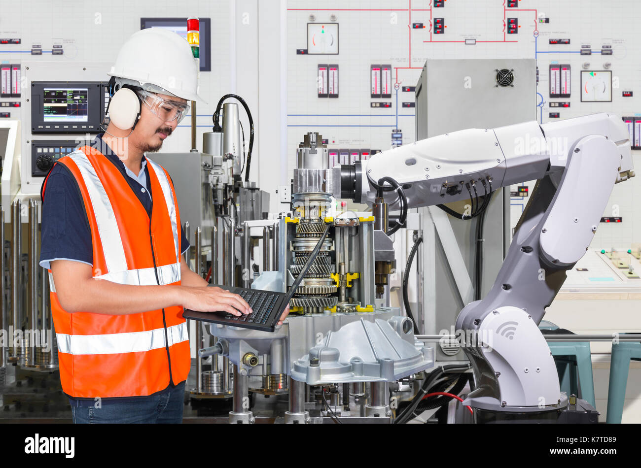 Ordinateur portable à l'aide de l'ingénieur pour l'entretien de la machine-outil automatique main robotique dans l'industrie automobile Banque D'Images