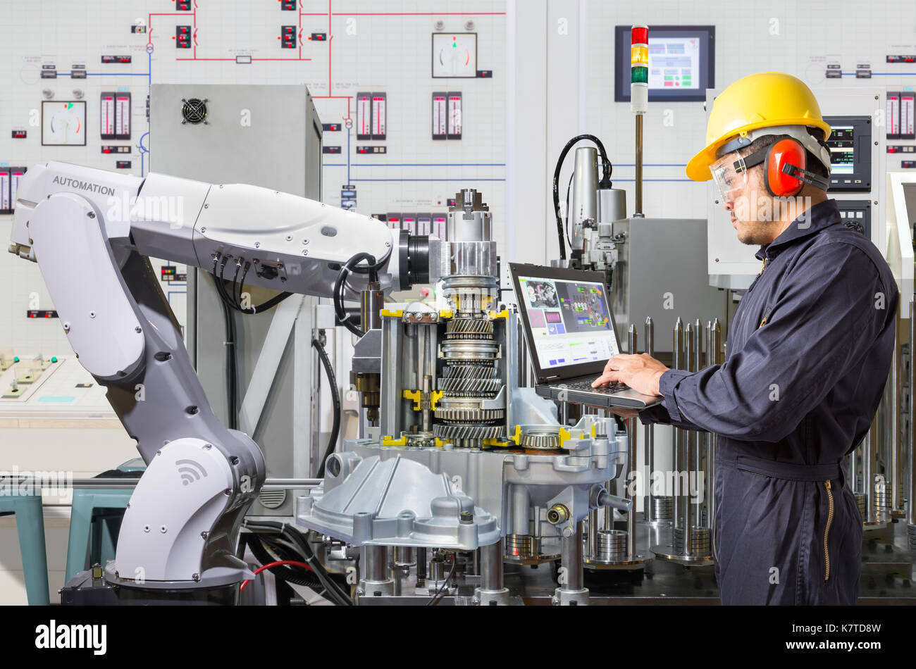 Ordinateur portable à l'aide de l'ingénieur pour l'entretien de la machine-outil automatique main robotique dans l'industrie automobile Banque D'Images