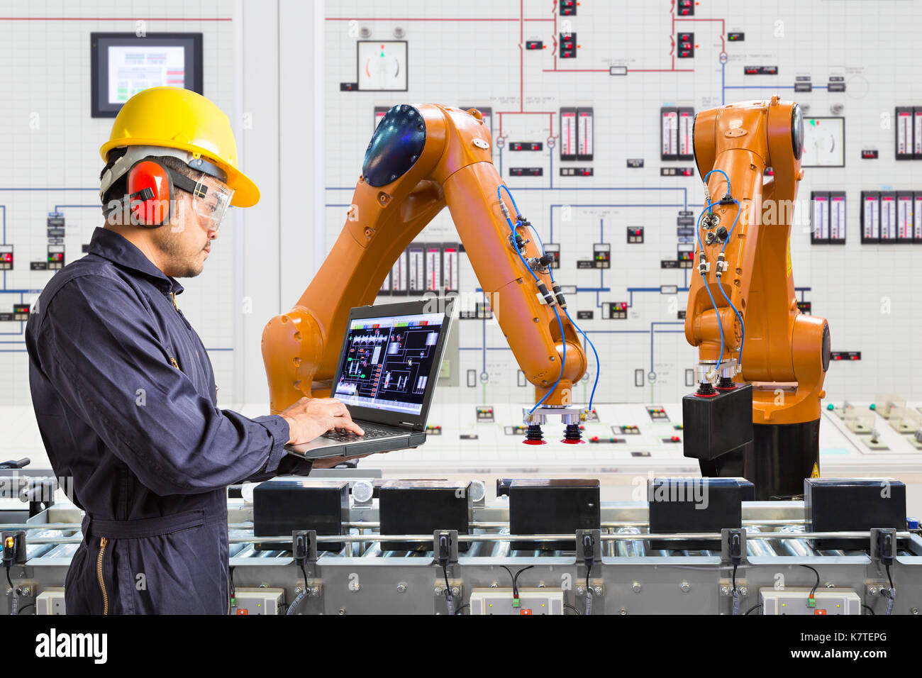 Ordinateur portable à l'aide de l'ingénieur pour l'entretien de la machine-outil main robotisée automatique dans smart factory, de l'industrie 4.0 concept Banque D'Images
