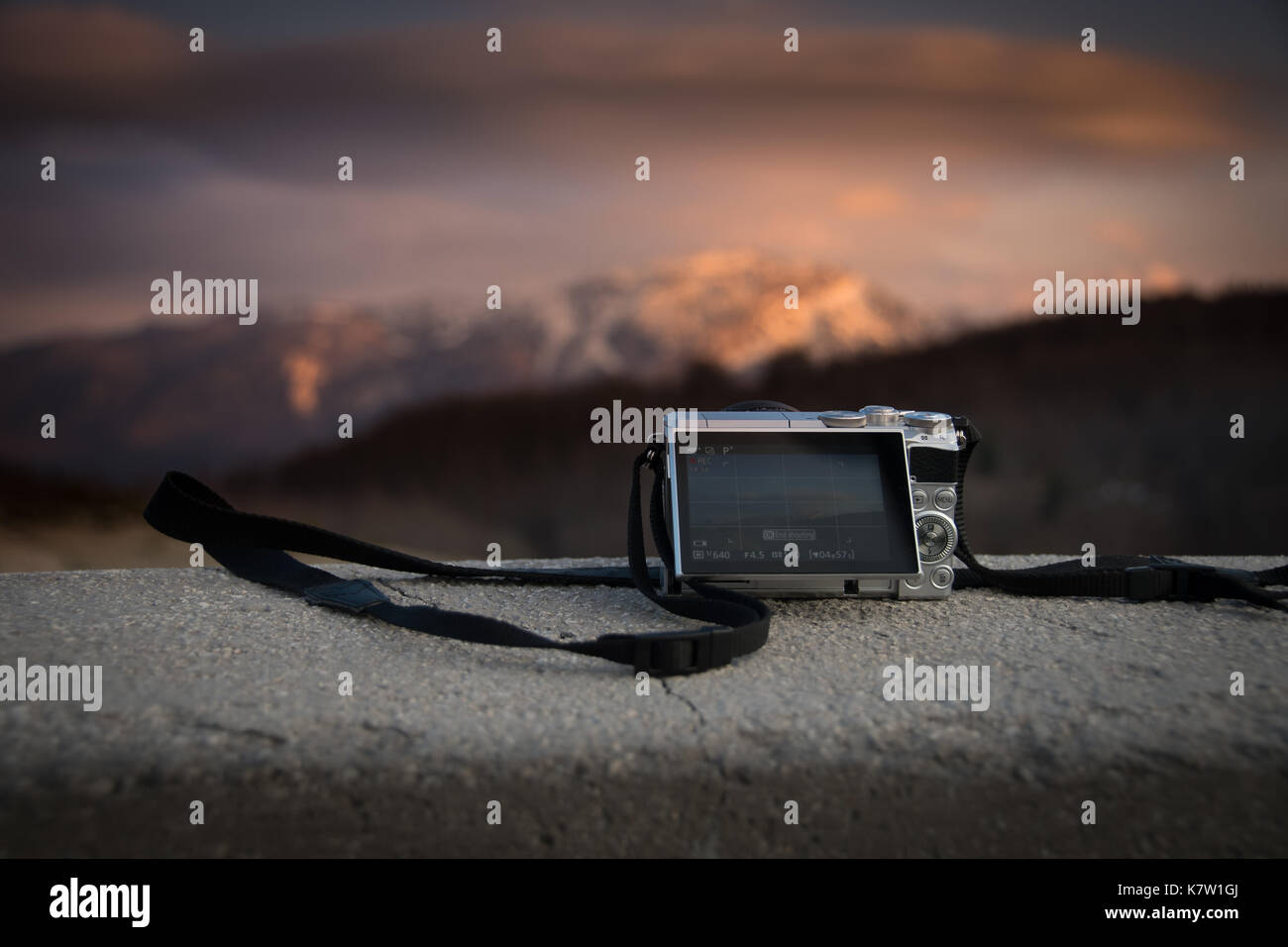 Petit miroir de poche appareil photo numérique moins de photographier le coucher de soleil sur montagne Banque D'Images