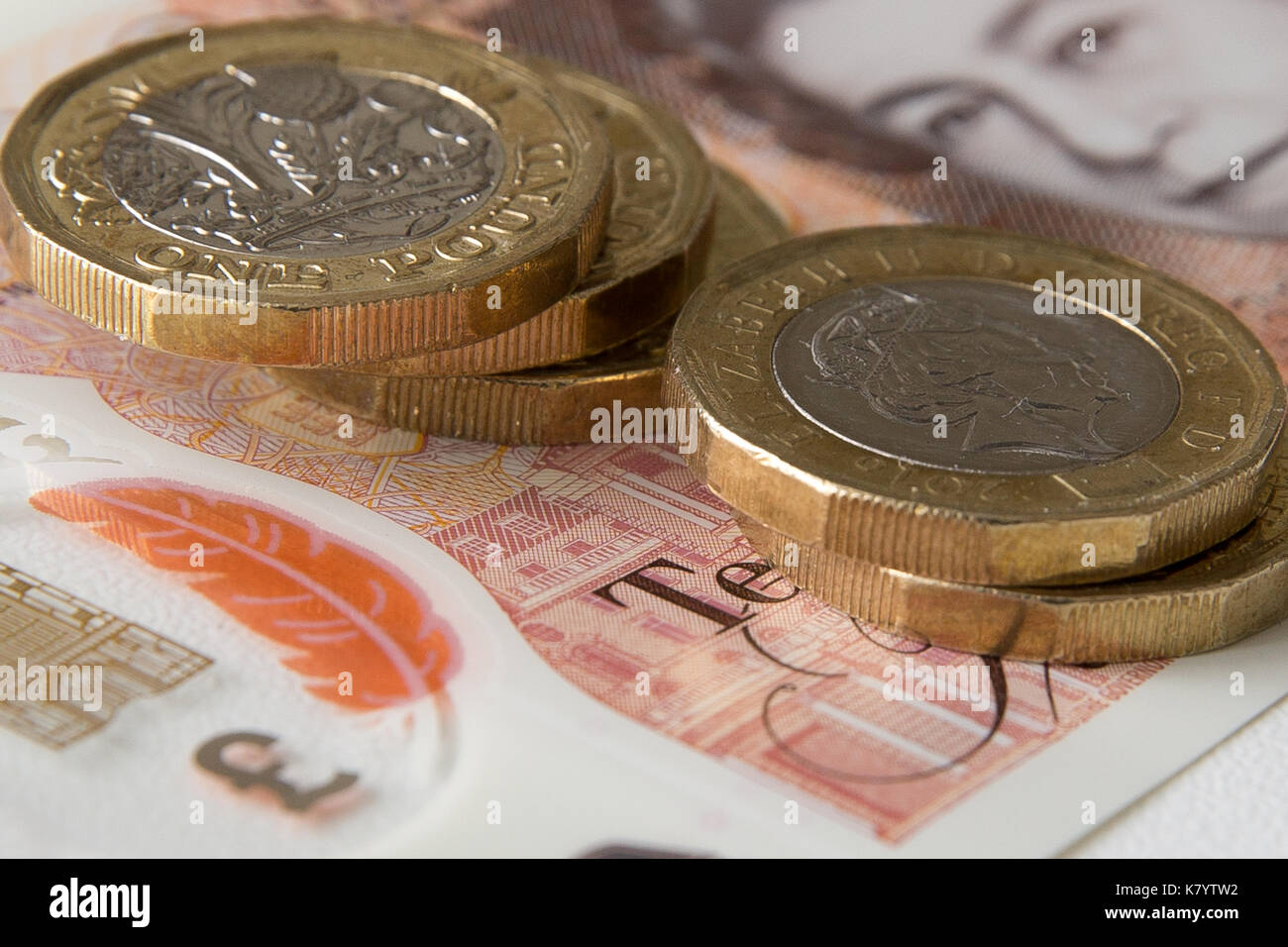 Image de la nouvelle, plastique, 10 lb, Sterling, remarque avec cinq pièces d'une livre sterling par dessus. Banque D'Images