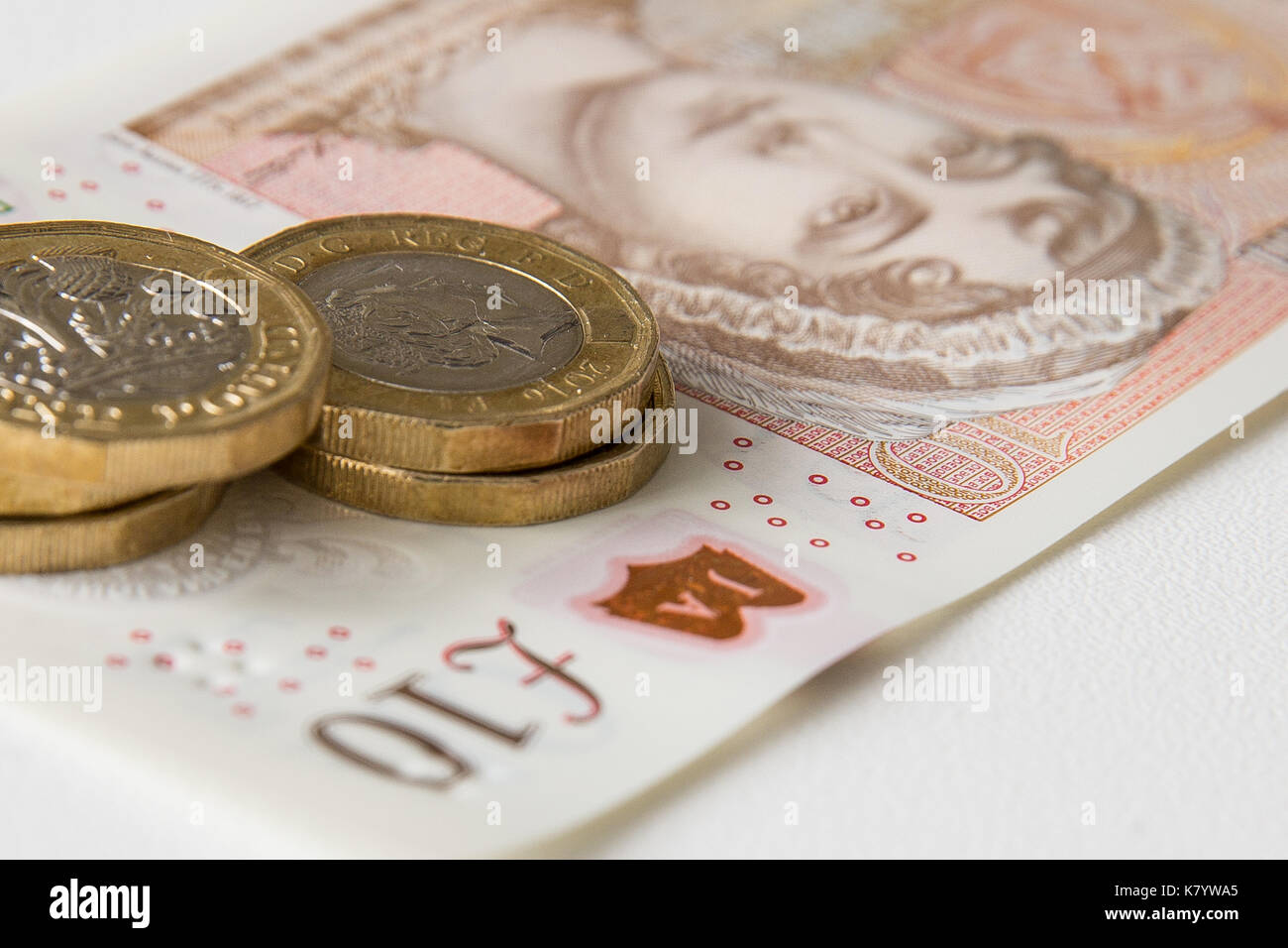 Image de la nouvelle, plastique, 10 lb, Sterling, remarque avec cinq pièces d'une livre sterling par dessus. Banque D'Images