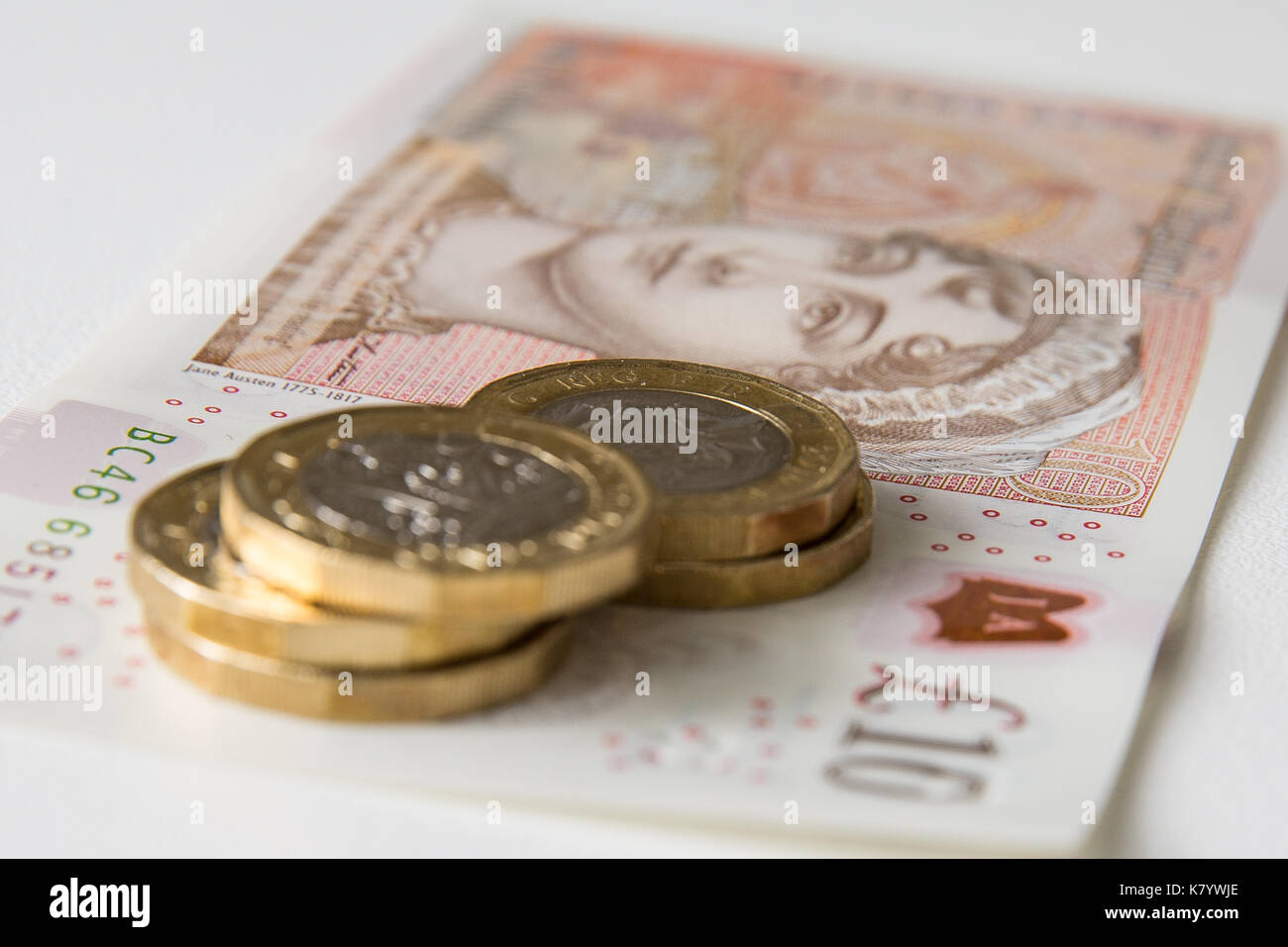Image de la nouvelle, plastique, 10 lb, Sterling, remarque avec cinq pièces d'une livre sterling par dessus. Banque D'Images
