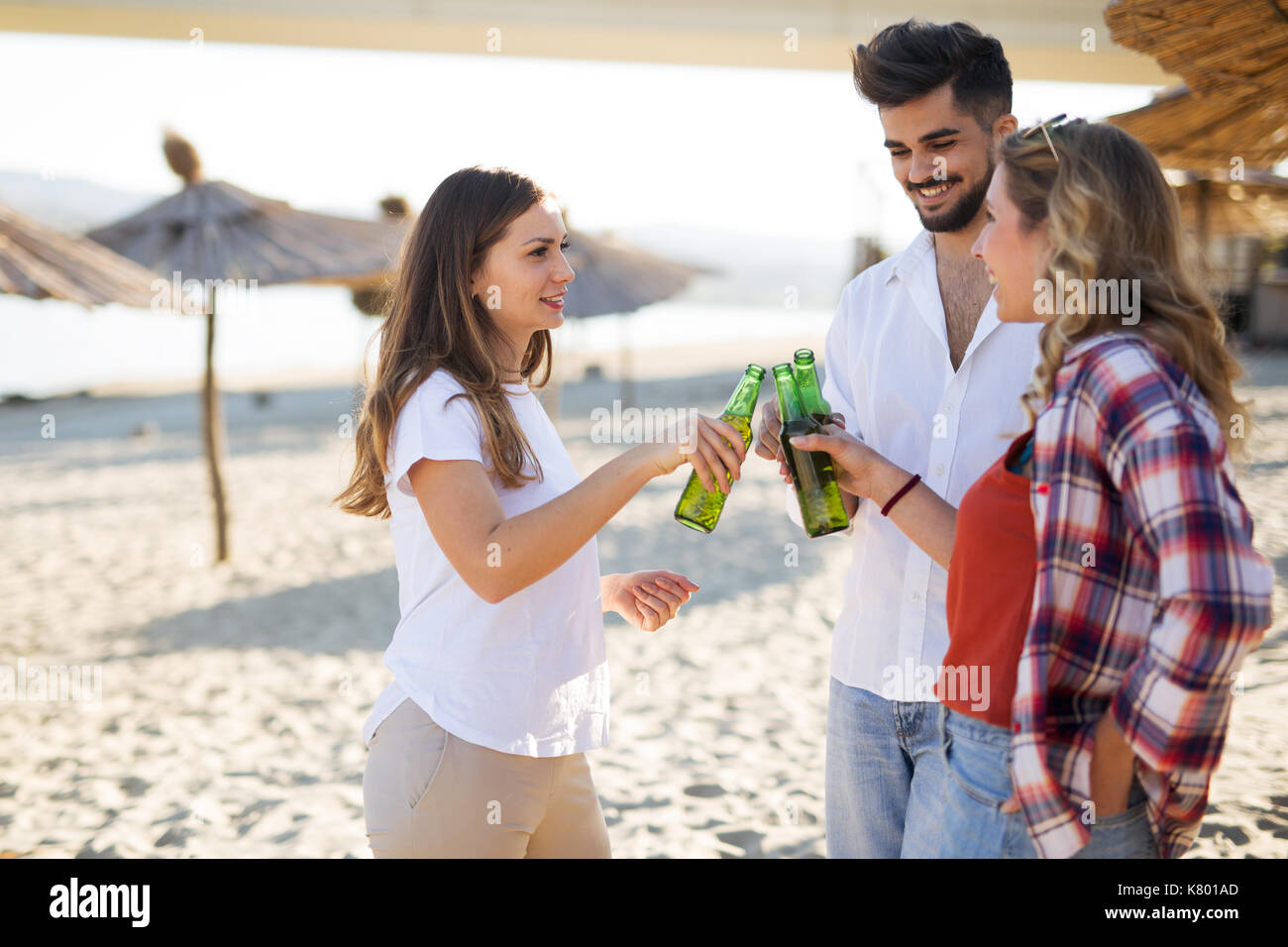 Les gens heureux de boire et s'amuser à la plage Banque D'Images