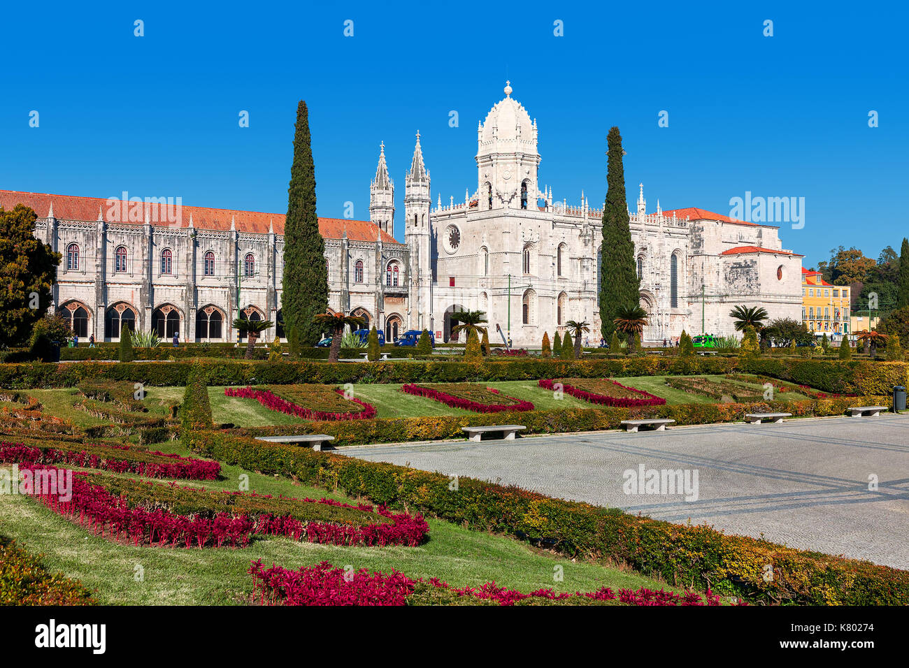 Vue sur parc urbain avec des fleurs et des jeronimos monastère des Hiéronymites (aka) sous ciel bleu à Lisbonne, Portugal. Banque D'Images