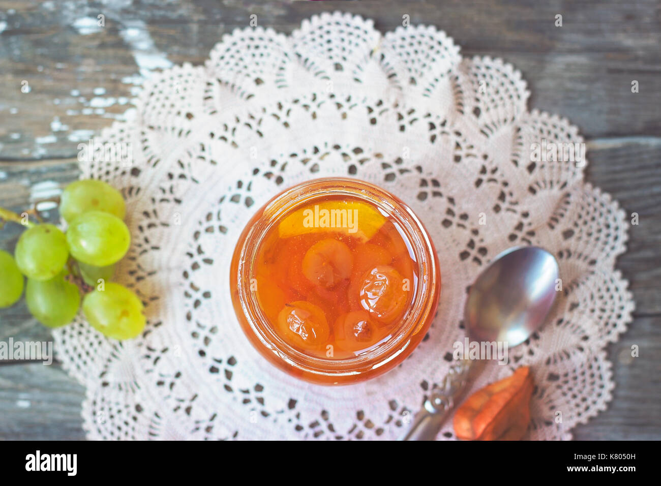 Slatko - Conserves de raisins blancs dans un bocal en verre, gris sur fond de bois traditionnelle serbe ; désert de raisin blanc ou blanc cerises Banque D'Images