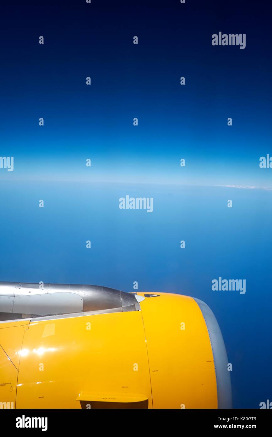 Vue de la fenêtre de l'avion d'un moteur d'avion contre un ciel bleu. Banque D'Images Vue de la fenêtre de l'avion d'un moteur d'avion contre un ciel bleu. Banque D'Images