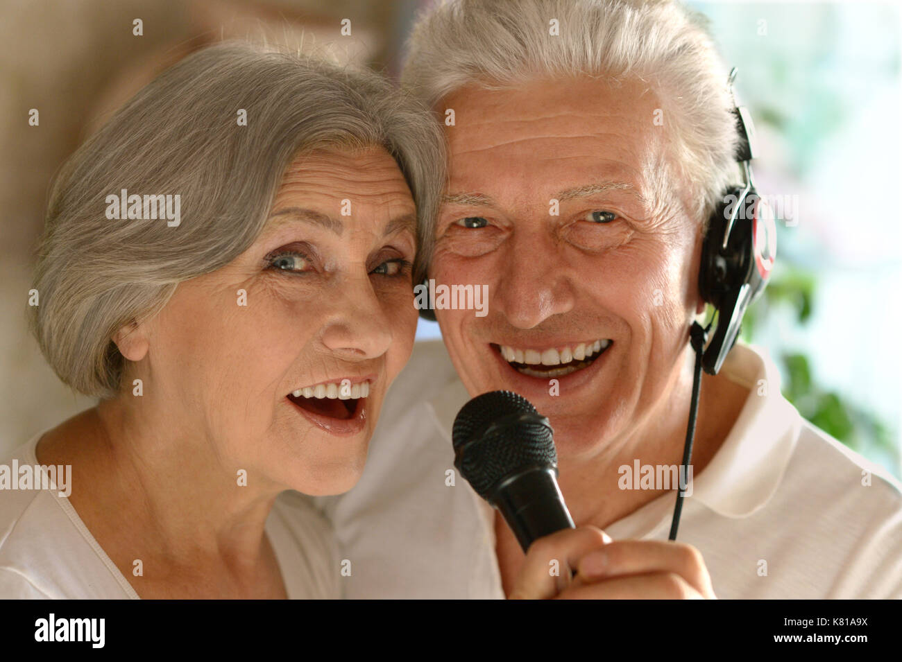 Senior couple singing karaoke Banque D'Images