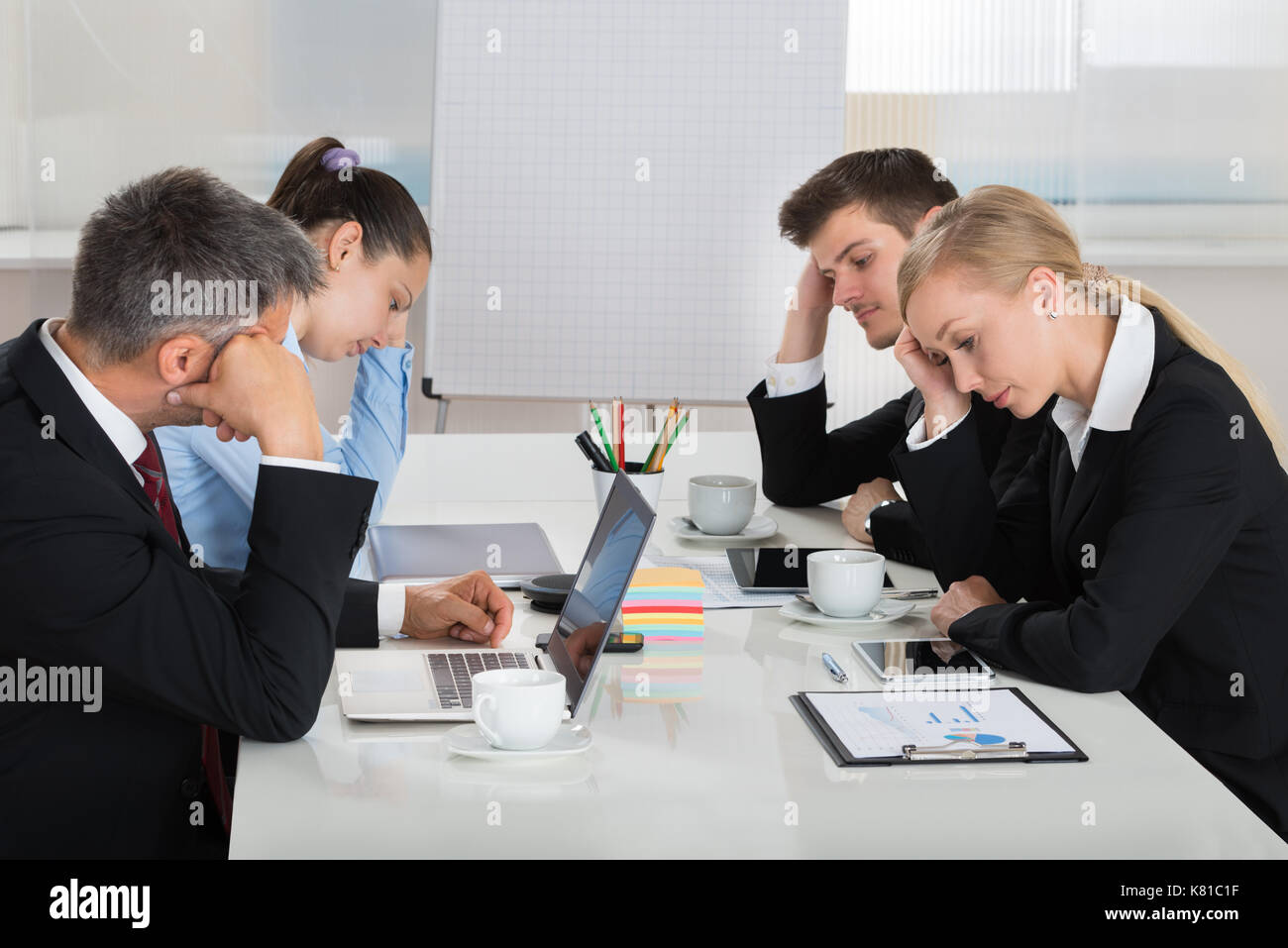 Équipe de malheureux businesspeople sitting in business meeting Banque D'Images