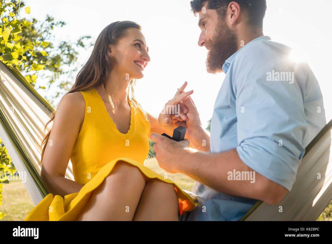 Homme heureux de mettre le doigt sur l'anneau d'enclenchement de l'petite amie sur Banque D'Images