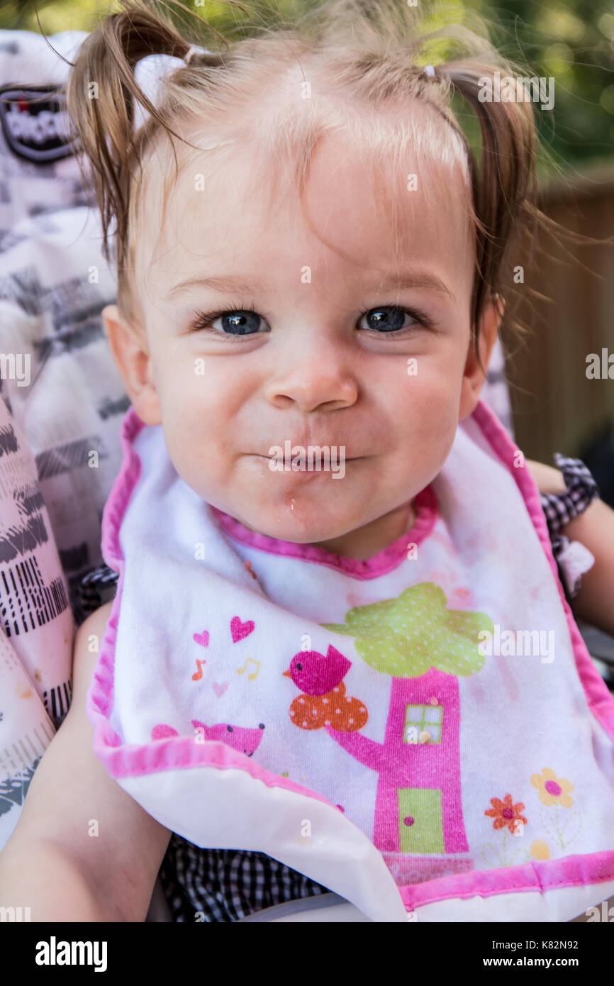 Heureux comme fille de 9 mois, elle mange des morceaux de pomme à  l'extérieur Photo Stock - Alamy