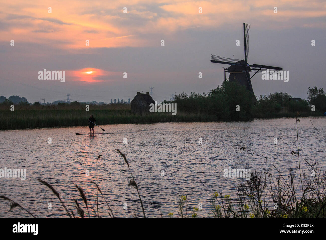 Lever de Soleil sur le moulin reflète dans le canal kinderdijk rotterdam Pays-Bas Hollande du Sud Europe Banque D'Images