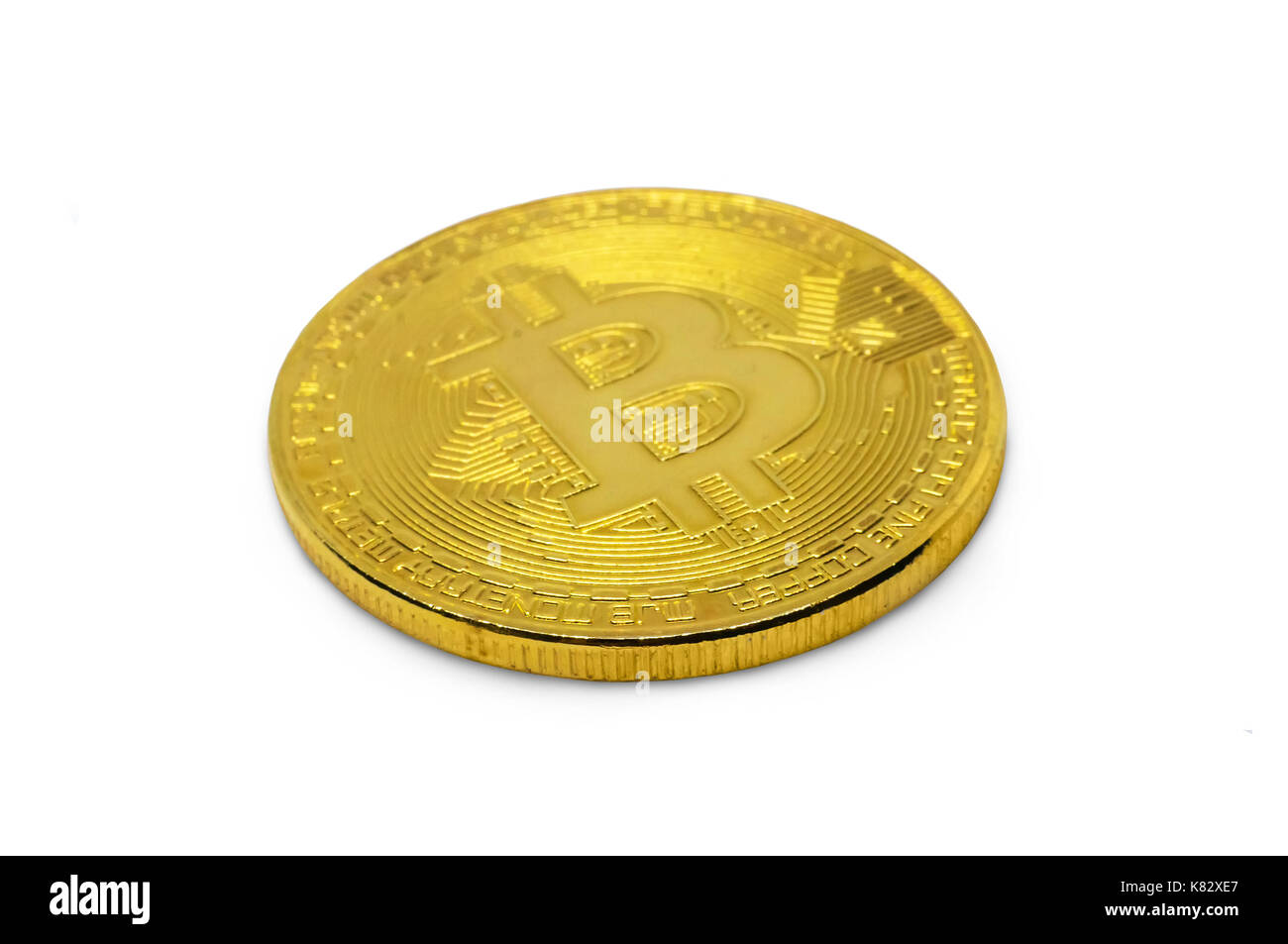 Bitcoin or isolé sur fond blanc. Pièce d'or brillant avec le symbole des bitcoins couchée sur le côté, sur un tableau blanc, close-up Banque D'Images