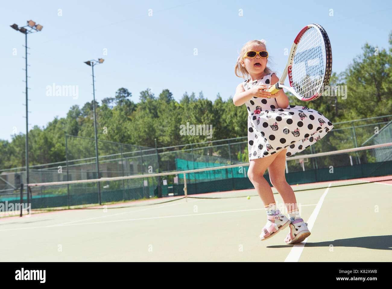 Happy little girl playing tennis Banque D'Images