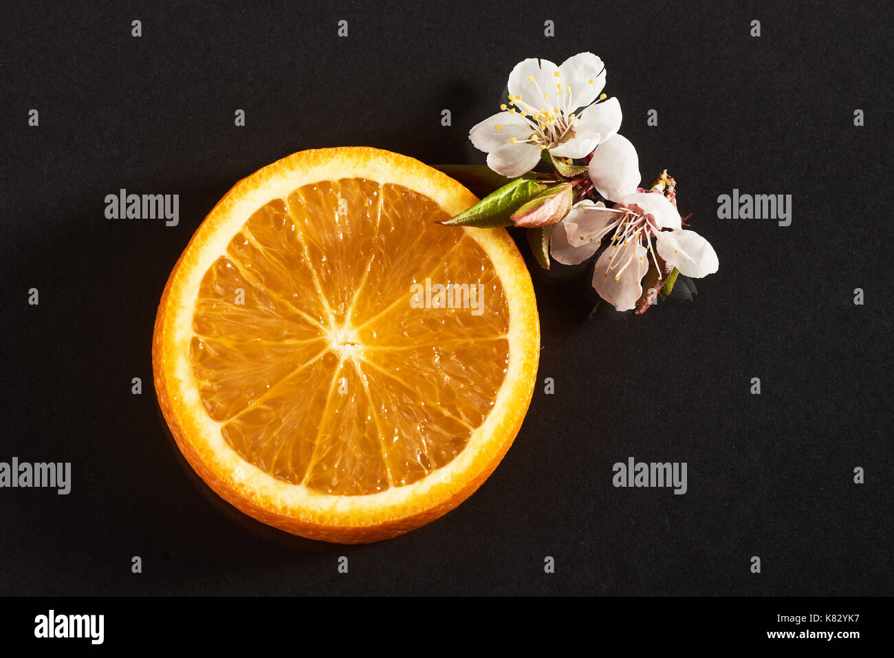 Couper les agrumes orange mûrs isolé sur un fond noir. Banque D'Images