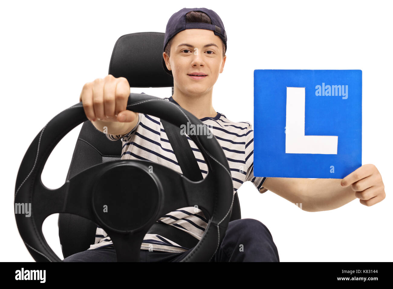 Teenage boy driving et montrant une l-sign isolé sur fond blanc Banque D'Images