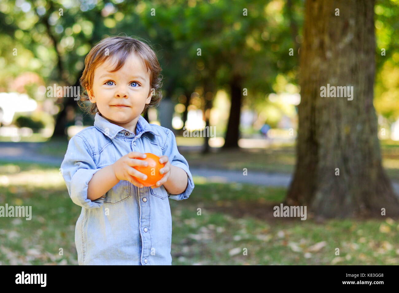 Adorable enfant âgé d'un an dans le parc à jouer avec son jouet Banque D'Images