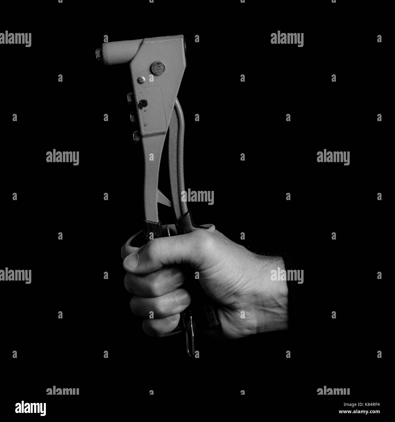- Outils à riveter dans une main d'homme - noir et blanc photo Banque D'Images
