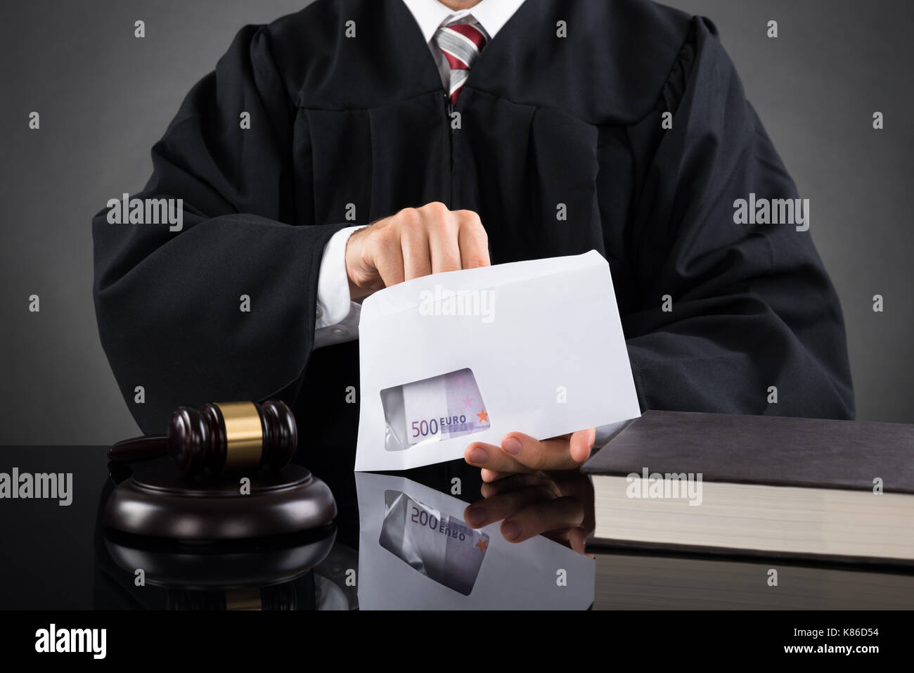 Close-up du juge de mettre l'argent dans une enveloppe au bureau, dans la salle d'audience Banque D'Images