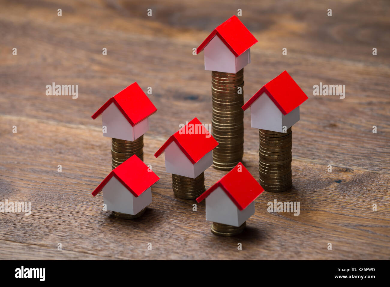 Modèles de maison sur pièces empilées à table en bois Banque D'Images