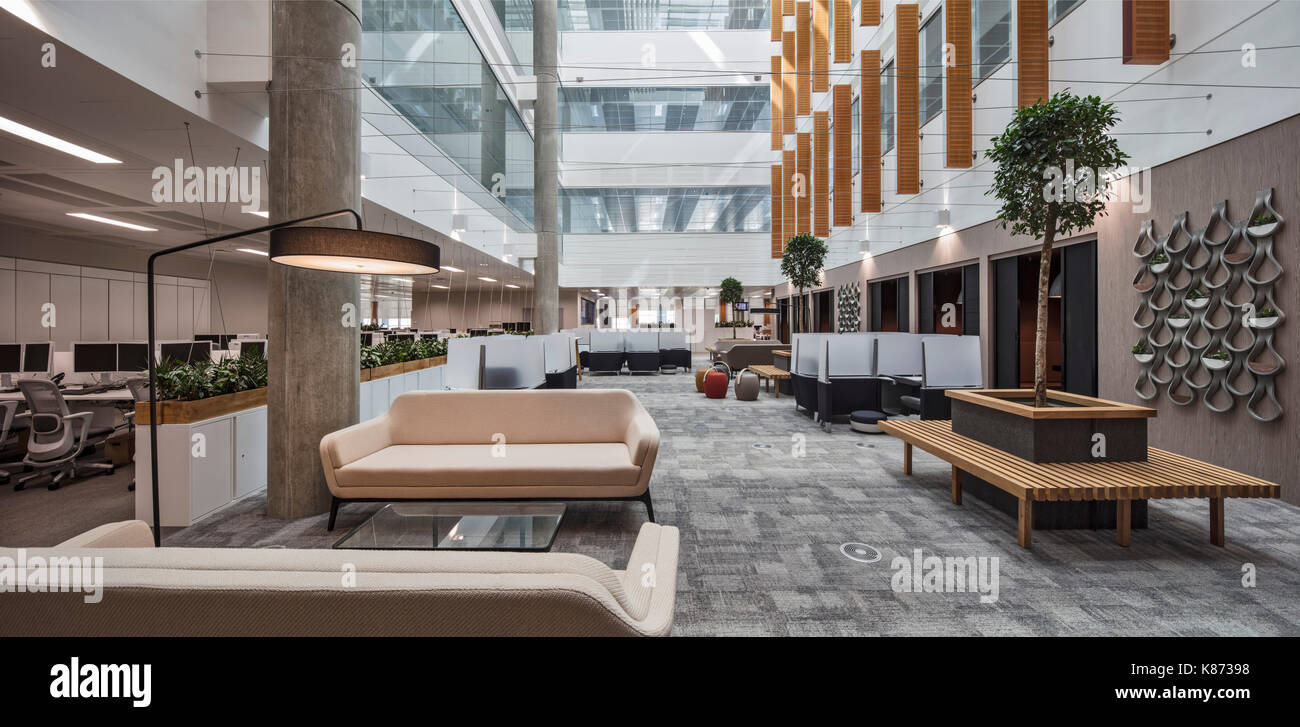 Les stations de travail et un coin salon dans l'atrium. YOOX Net-A-Porter Bureaux, Londres, Royaume-Uni. Architecte : Grimshaw, 2017. Banque D'Images