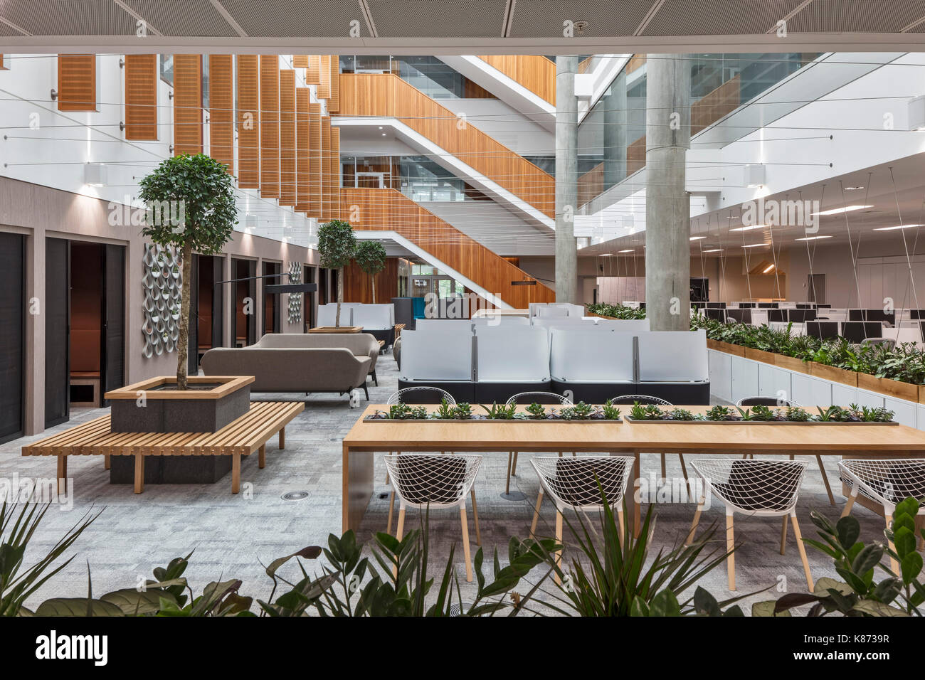 Les stations de travail dans l'atrium. YOOX Net-A-Porter Bureaux, Londres, Royaume-Uni. Architecte : Grimshaw, 2017. Banque D'Images