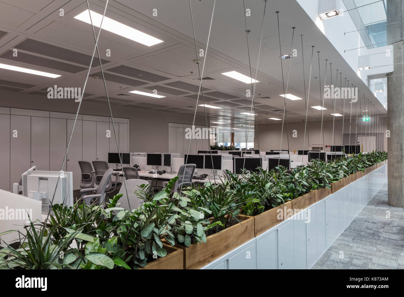 Les stations de travail à côté de l'atrium. YOOX Net-A-Porter Bureaux, Londres, Royaume-Uni. Architecte : Grimshaw, 2017. Banque D'Images