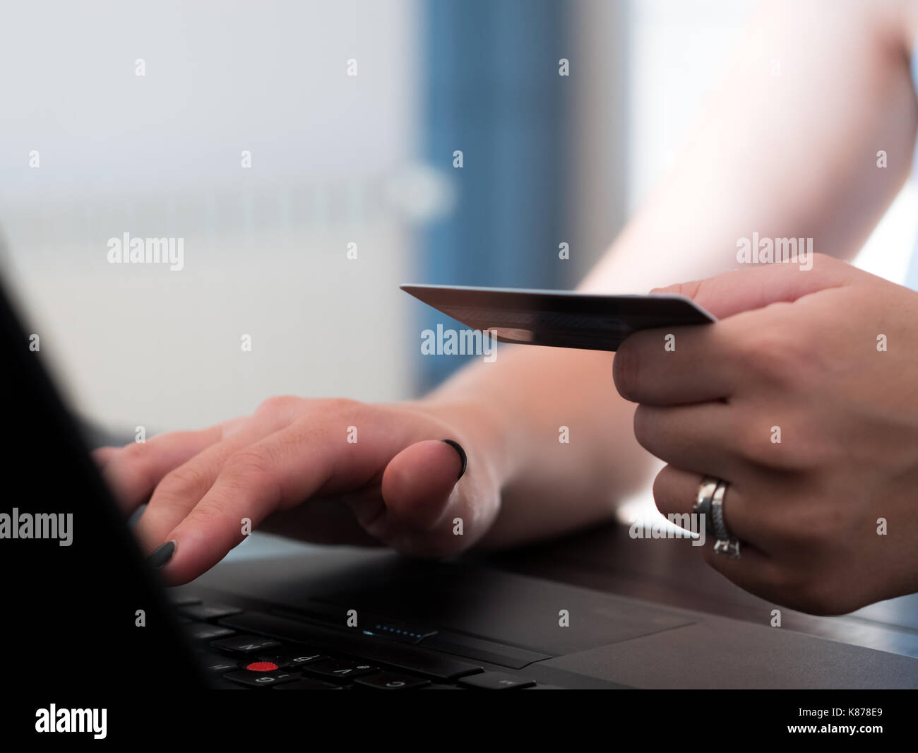 Jeune femme l'achat en ligne sur internet avec ordinateur portable et carte de crédit Banque D'Images