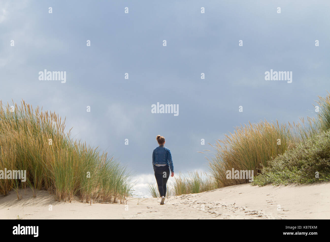 Fille qui marche dans les dunes Banque D'Images