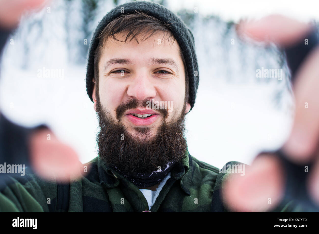 Homme barbu tenant on snowy mountain selfies close up Banque D'Images