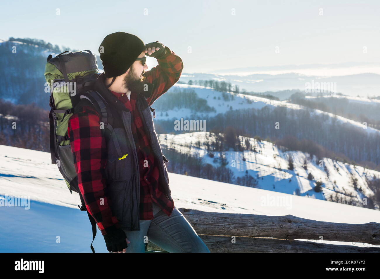 Homme barbu randonneur sur une montagne enneigée randonnée d'hiver. Banque D'Images