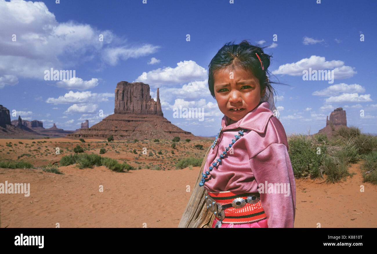 Une jeune fille Navajo, vêtu de vêtements en velours doux traditionnel et de l'argent et turquoise bijoux, près de sa mère, Hogan dans Monument Valley Navajo Tri Banque D'Images