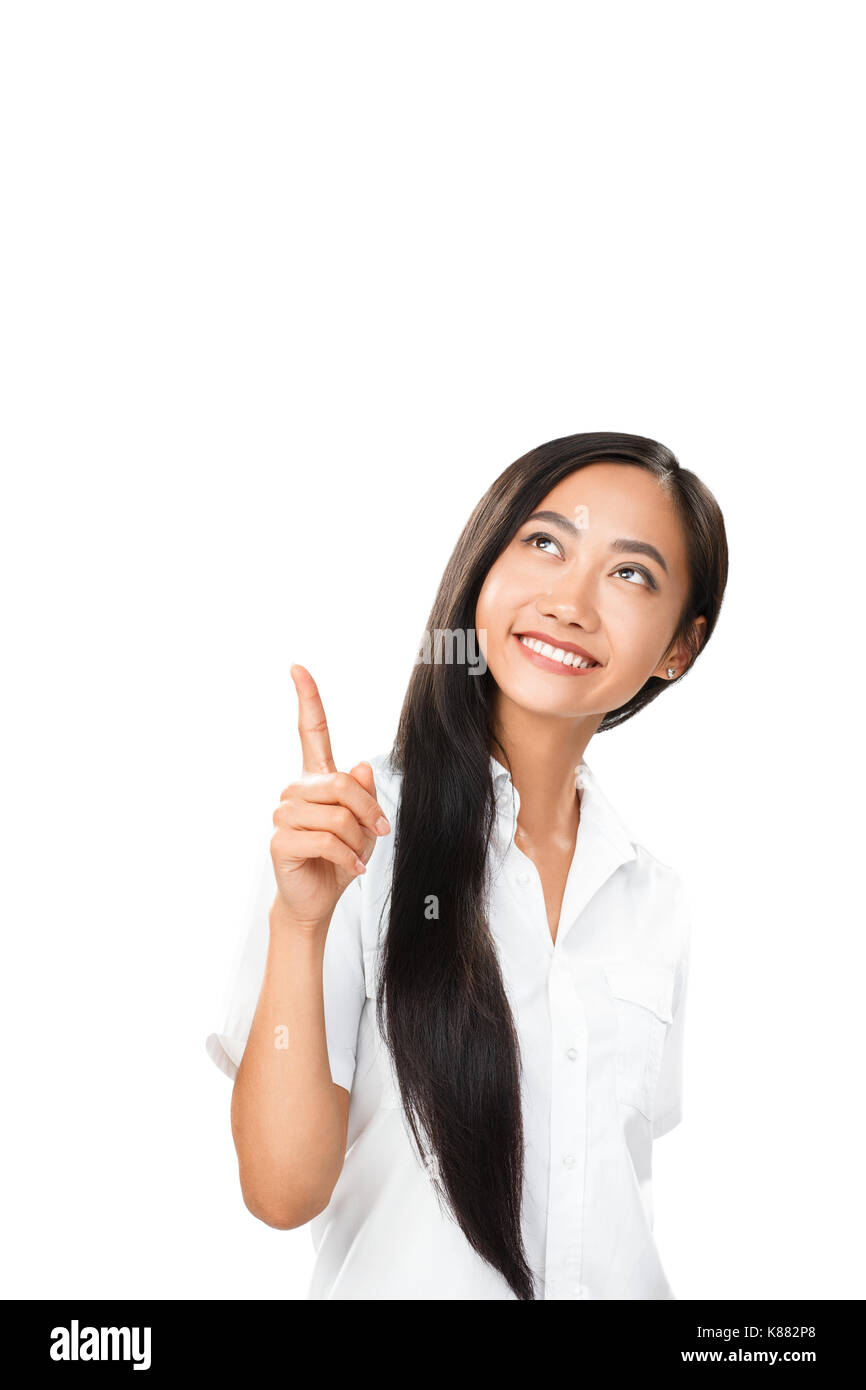 Carefree smiling Asian woman pointing finger, et l'avenir. Image avec copyspace isolé sur fond blanc. La photo pour divers besoins de conception, de bus Banque D'Images