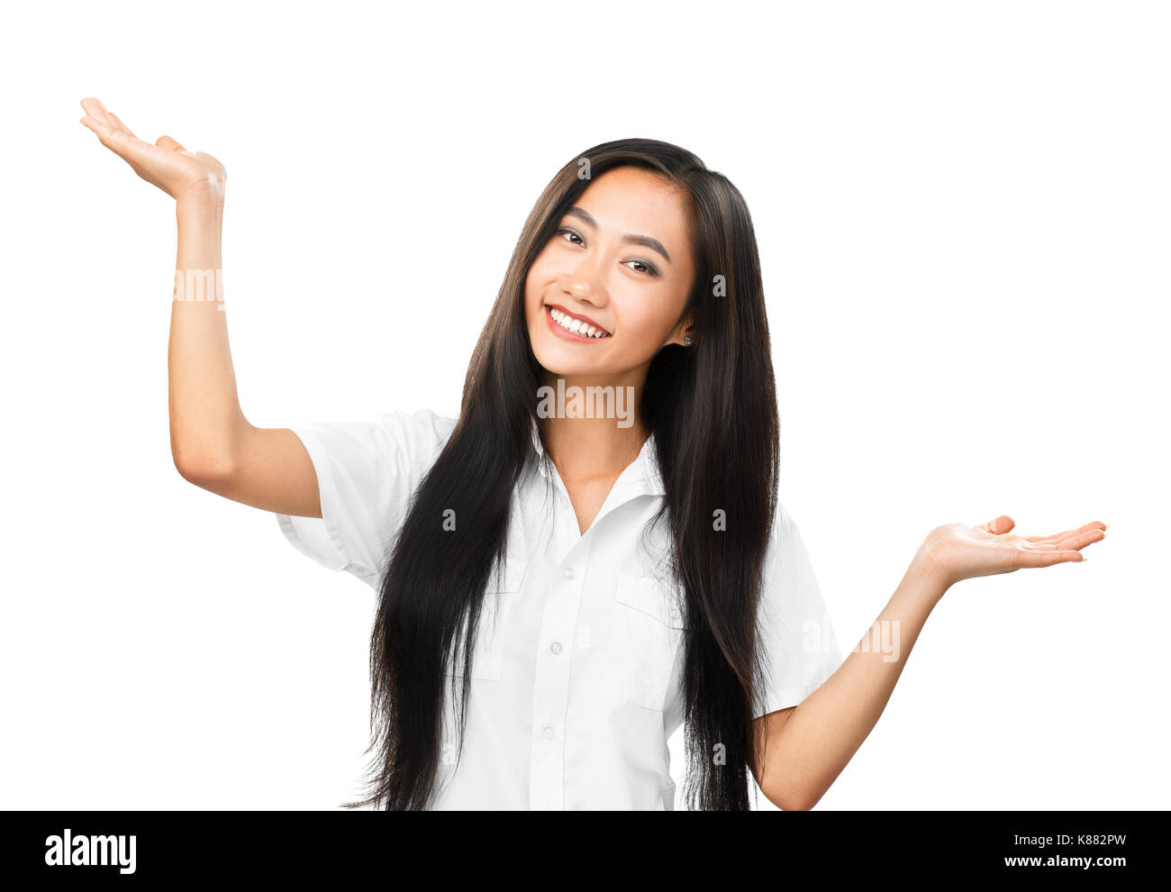 Cheerful asian woman with long hair faisant des gestes avec les mains et en regardant la caméra. moitié du corps, portrait of smiling très belle orientale montrant la bala Banque D'Images