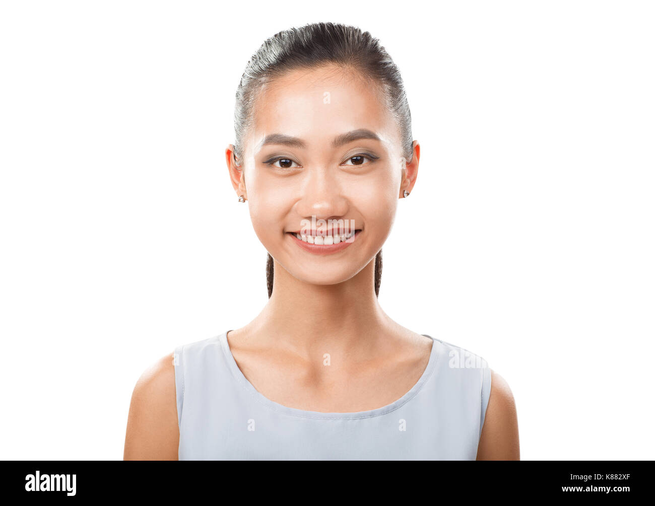 Smiling portrait gros plan femme asiatique. Très belle orientale avec du make-up et une queue de cheveux. Beau visage avec la peau fraîche isolé sur zone blanche Banque D'Images