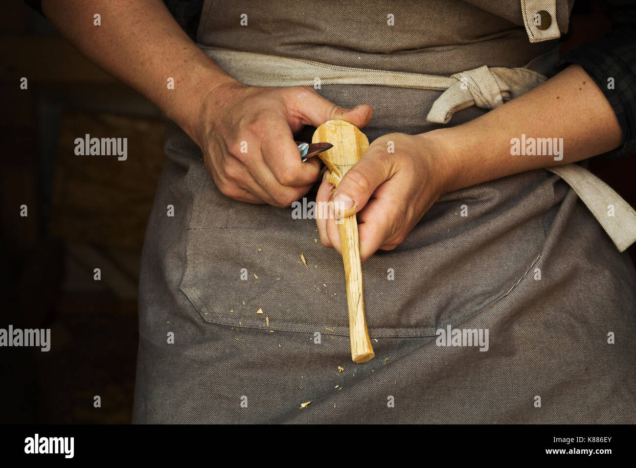 Close up d'un artisan façonner un petit morceau de bois avec un couteau pointu. Banque D'Images