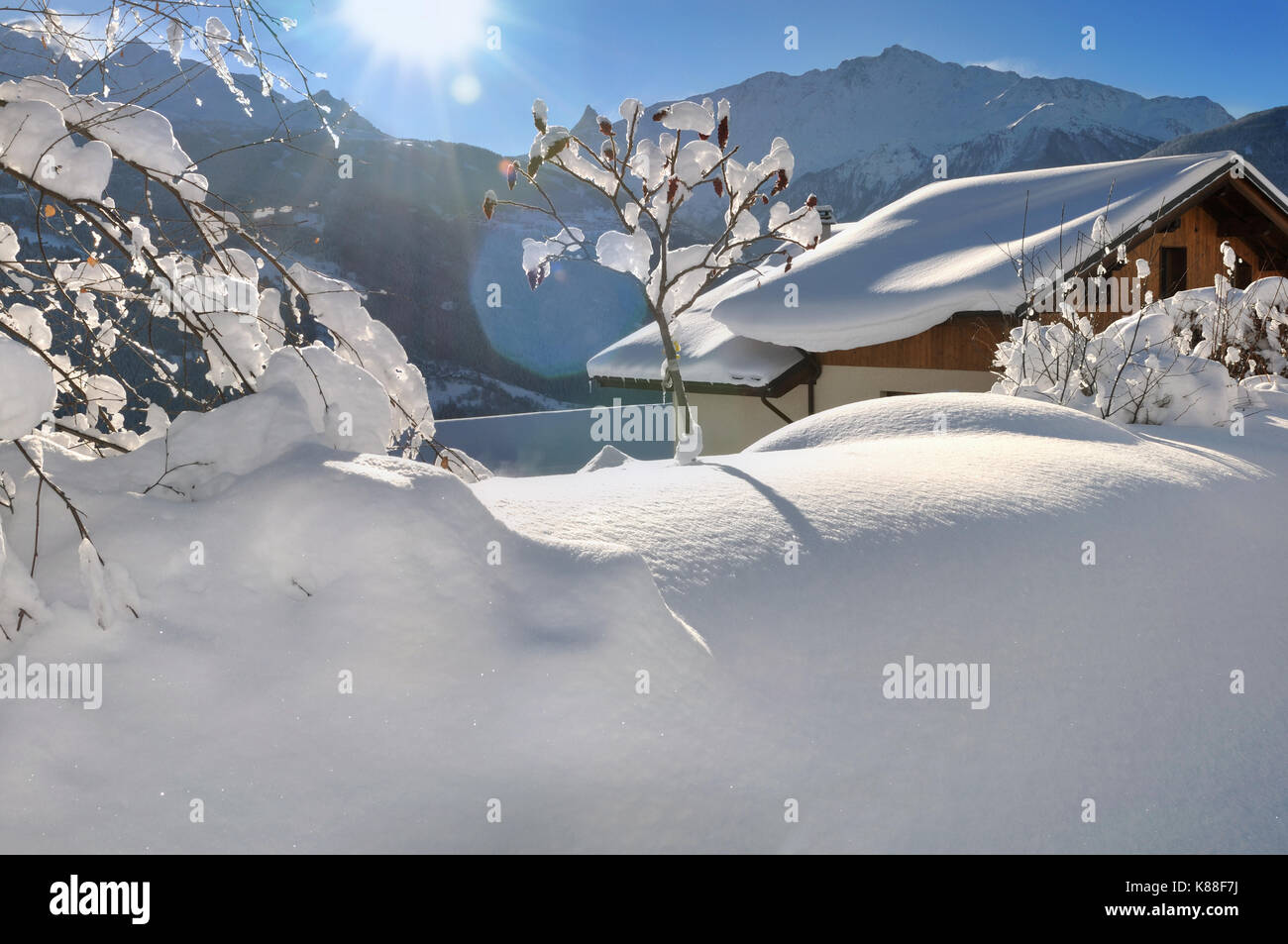 Chalet en bois sur la neige sous soleil Banque D'Images