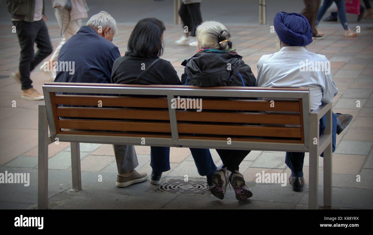 Couple sikh et asian couple assis sur un banc sur le mile style Buchanan Street Glasgow Banque D'Images