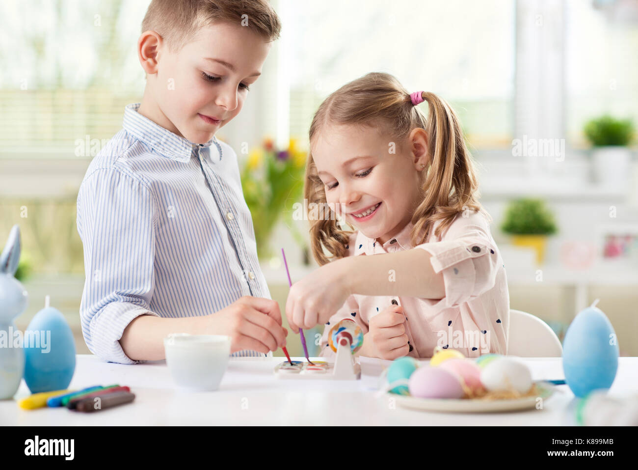 Deux enfants heureux de s'amuser lors de la mise en peinture d'oeufs de Pâques dans le printemps ! Banque D'Images