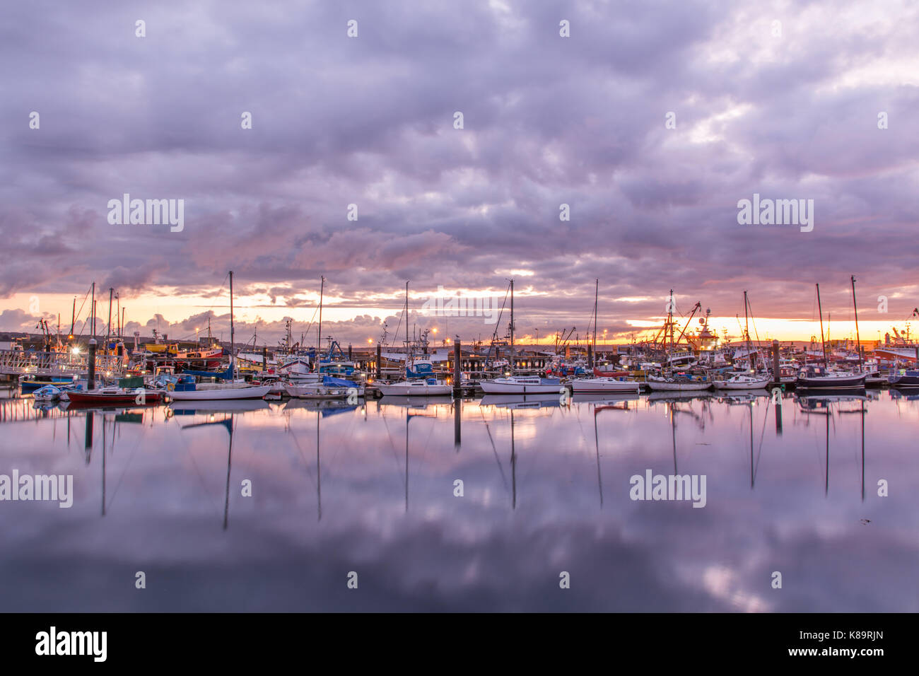 Newlyn, Cornwall, UK. Sep 19, 2017. Météo britannique. Malgré les nuages bas au lever du soleil, le port de Newlyn illuminé avec les couleurs de l'ciel reflète ce matin. Crédit : Simon Maycock/Alamy Live News Banque D'Images