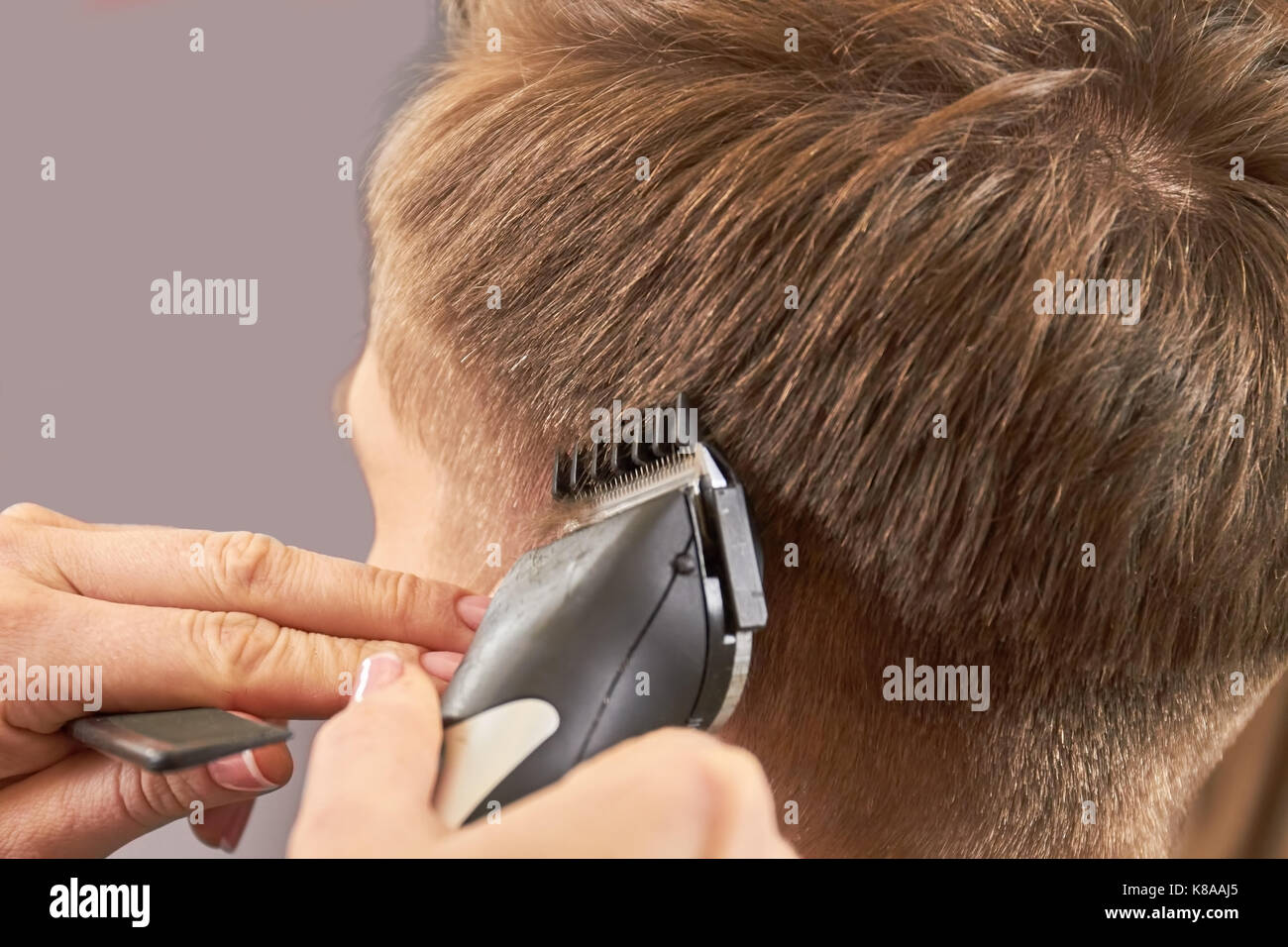 Tondeuse à cheveux à l'aide de mains. Banque D'Images