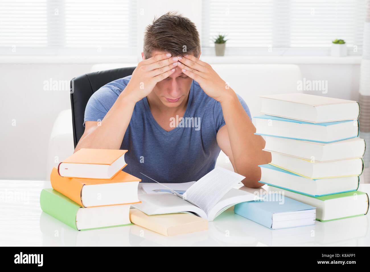 Portrait de jeune homme fatigué d'étudier des livres à 24 Banque D'Images