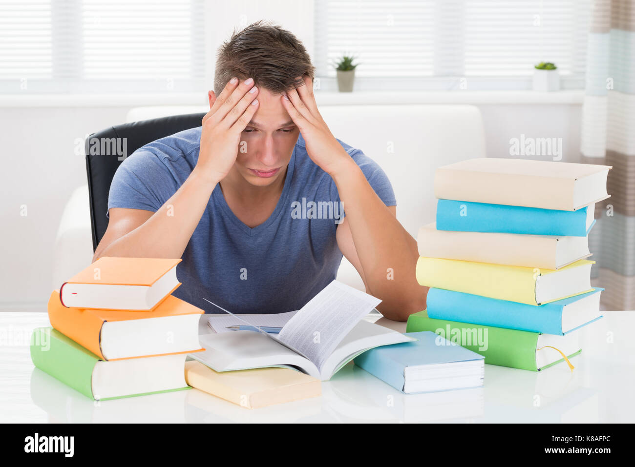 Portrait de jeune homme fatigué d'étudier des livres à 24 Banque D'Images