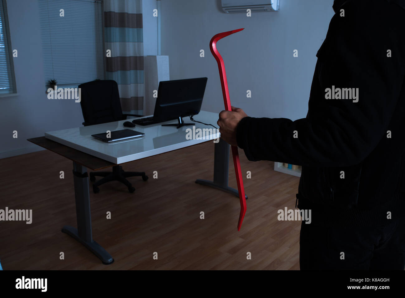 Close-up of Burglar Holding Crowbar In Office Banque D'Images
