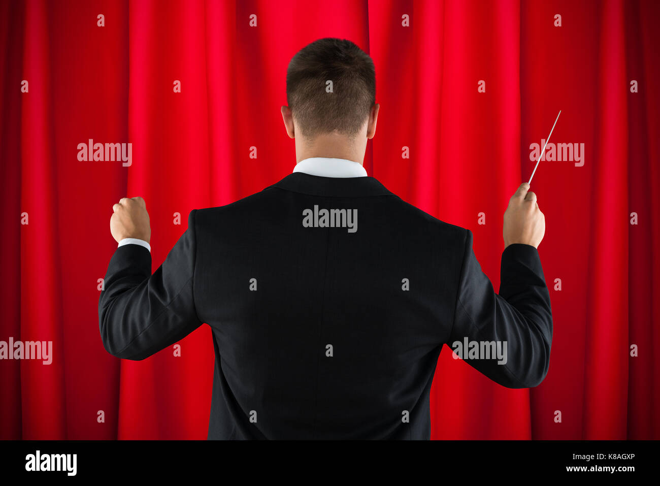 Vue arrière de l'homme d'orchestre de diriger avec son bâton Banque D'Images